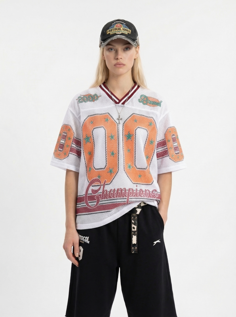 Model wearing a white mesh jersey T-shirt with orange 00 graphic and maroon stripes, styled with black pants and a black cap