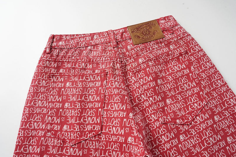 Back of red script print pants with tan logo patch and rear pocket