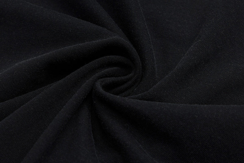 Close-up of black fabric with soft spiral folds, matching a vintage comic graphic tee design