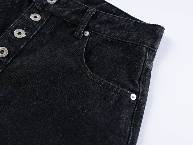 Front pocket and waistband close-up on black denim shorts with silver rivets