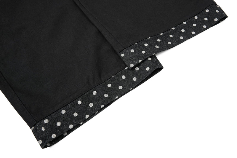 Close-up of black denim hem with polka dot cuff trim
