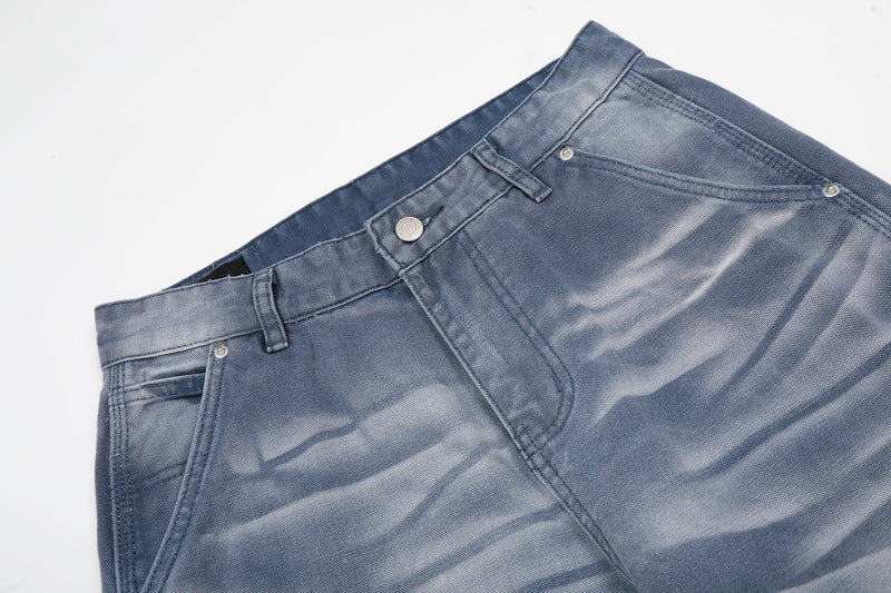 Close-up of blue denim waistband with button, belt loops, and front pocket edge