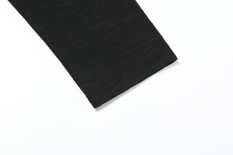 Black sleeve cuff detail showing ribbed knit fabric and hem stitching