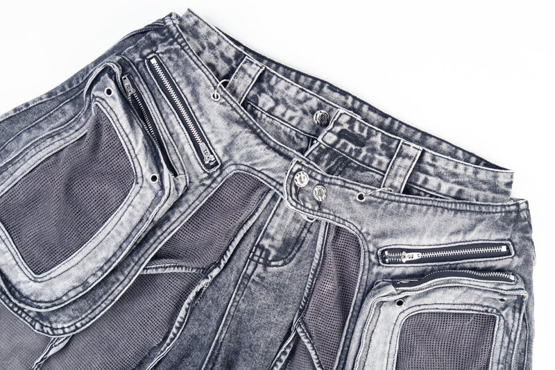 Top view of gray distressed jeans showing mesh cargo pockets and zipper details