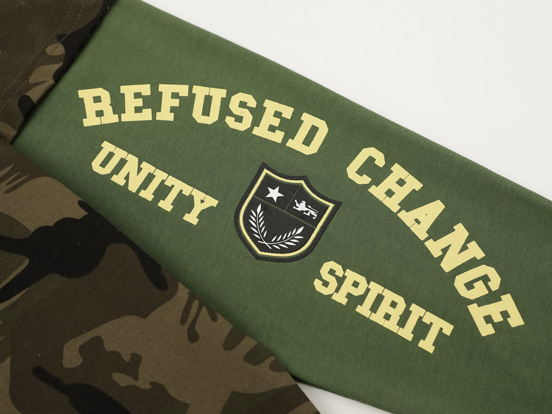 Close-up of green sleeve with yellow REFUSED CHANGE SPIRIT text and crest patch