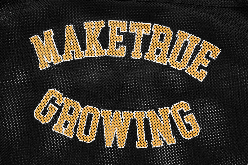 Black mesh varsity jersey with arched yellow make trouble and growing lettering on the front