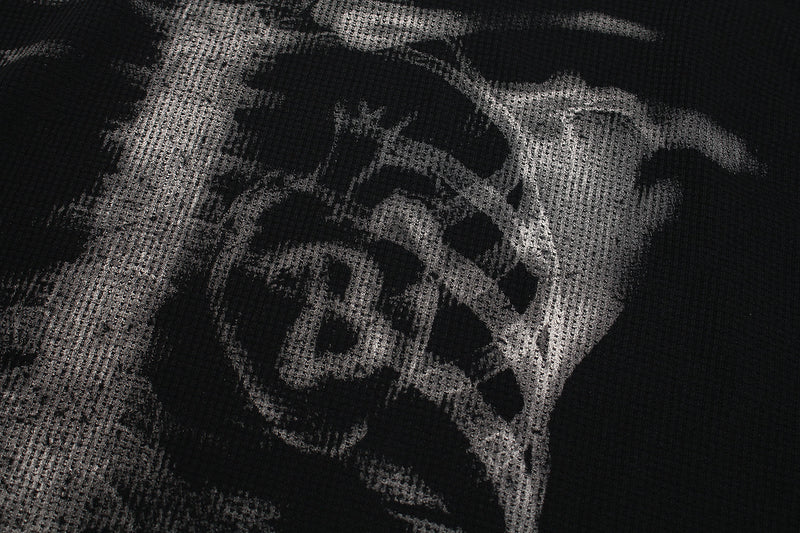 Close-up of front torso print showing skull details on black waffle-knit long sleeve tee