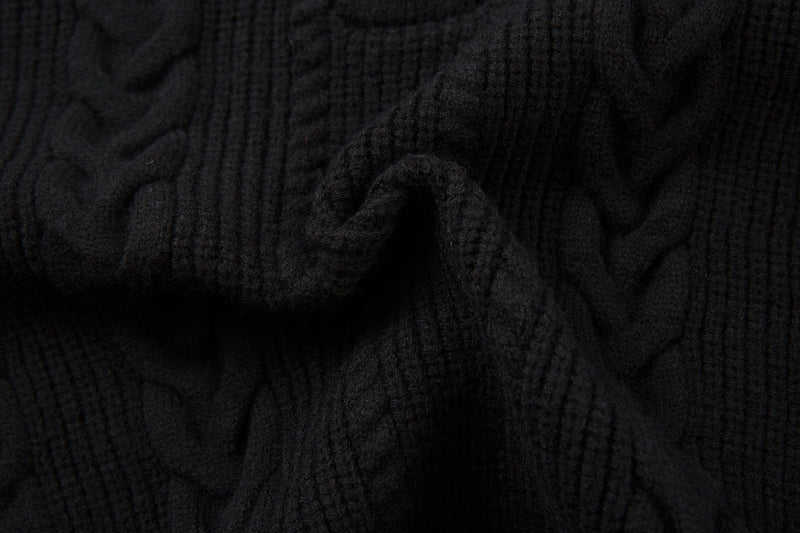 Close-up of black sweater knit fabric with soft textured cable pattern