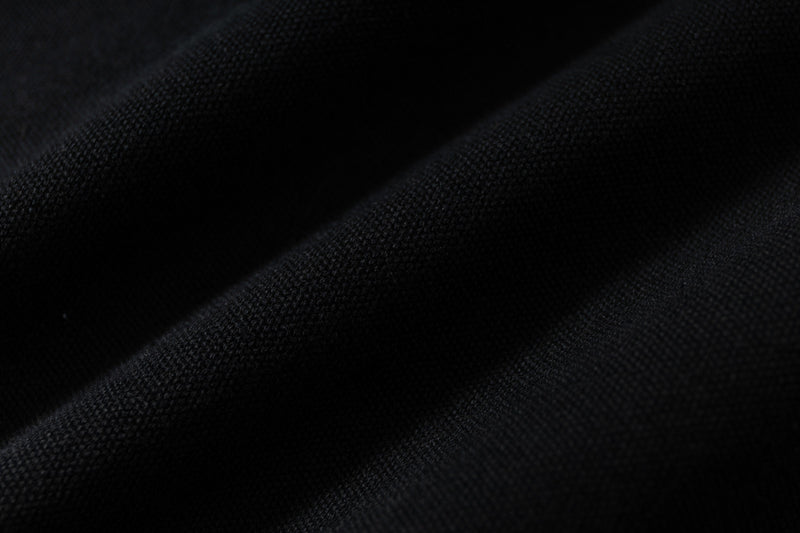 Close-up of black hoodie fabric texture with soft diagonal folds