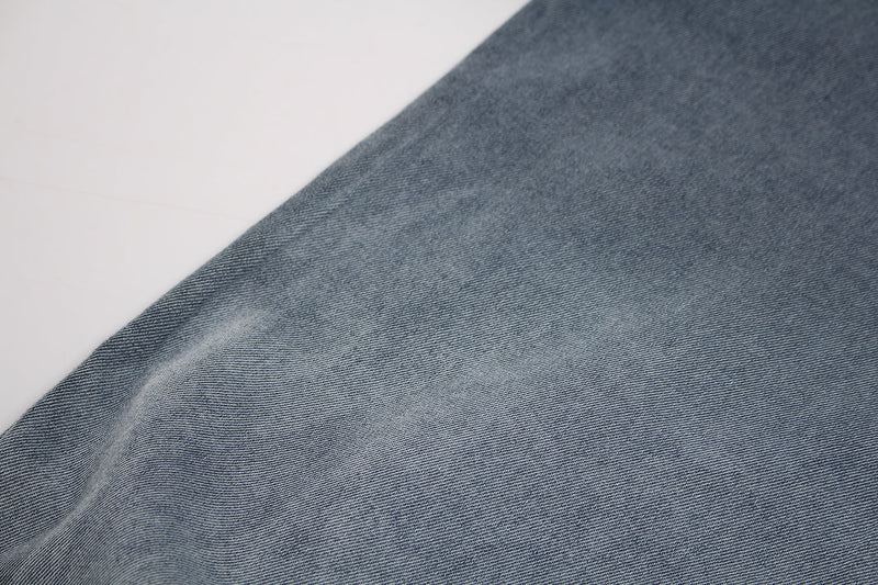 Close-up of a vintage washed blue distressed graphic T-shirt with soft faded denim-like texture