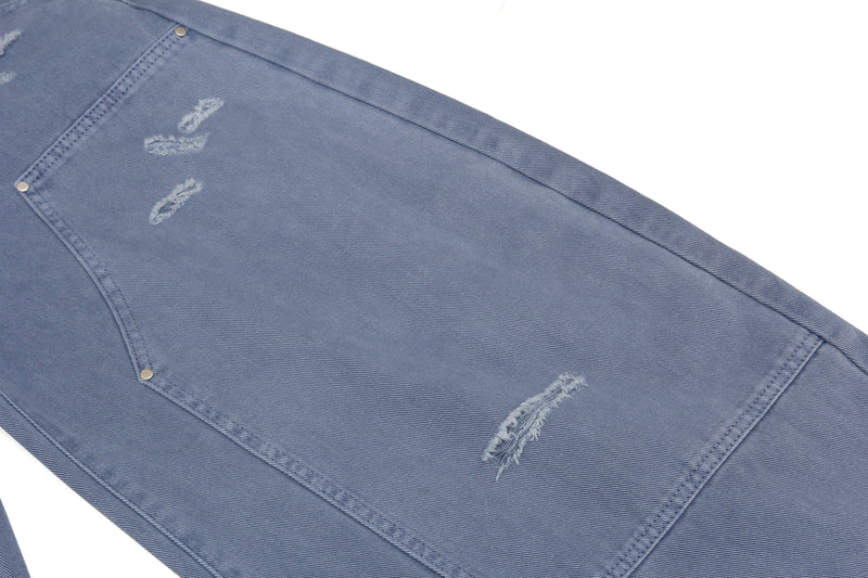 Close-up of back leg panel on blue jeans with distressed rips and stitching