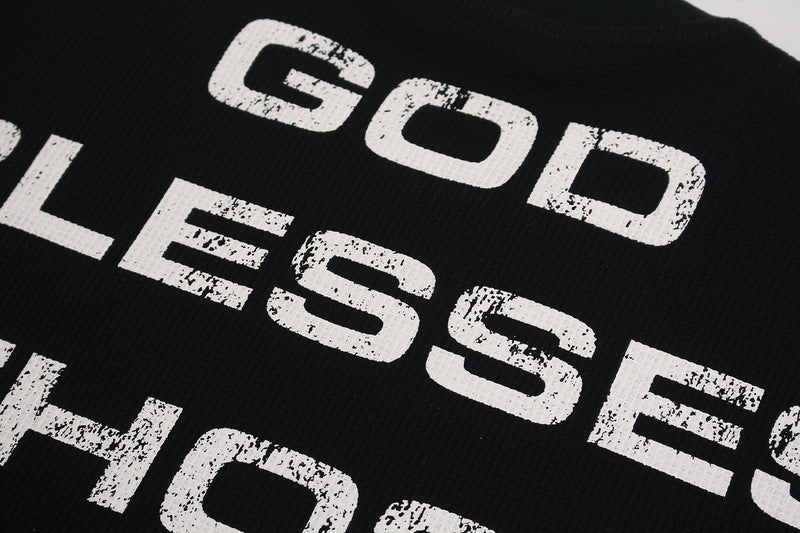 Black streetwear graphic tee with distressed white typography print on textured fabric close-up