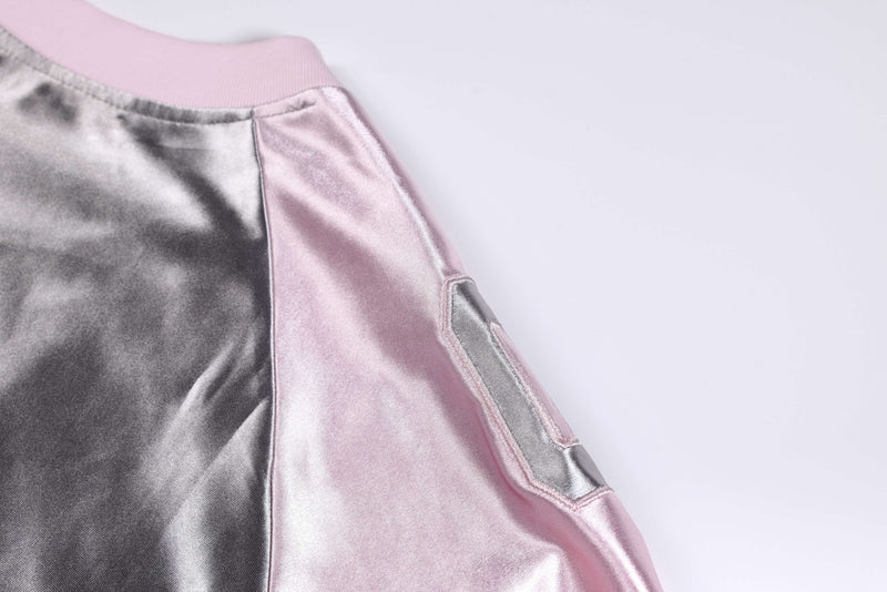 Close-up of a metallic pink and silver oversized varsity jersey tee with satin finish and shoulder detail
