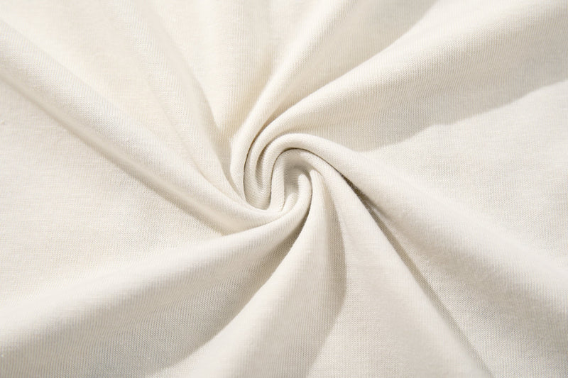Close-up of cream fabric twisted to show soft knit texture