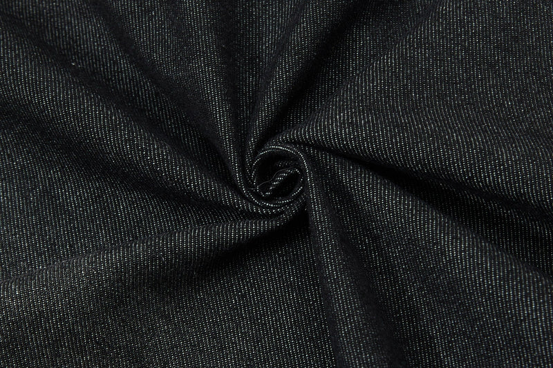 Close-up of black denim fabric with subtle white speckled texture and visible twill weave from a streetwear button-up shirt