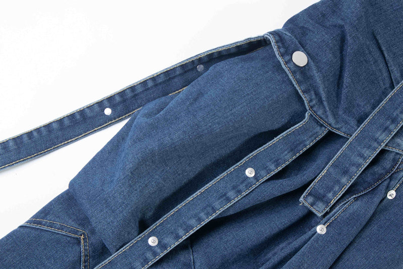 Close-up of blue denim cargo pocket and side strap with snap buttons