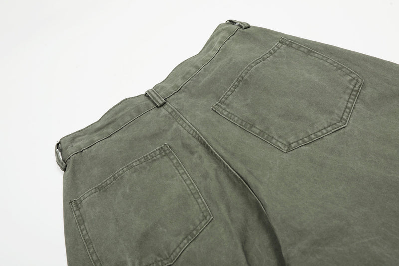 Close-up of olive green pants back pockets and yoke stitching