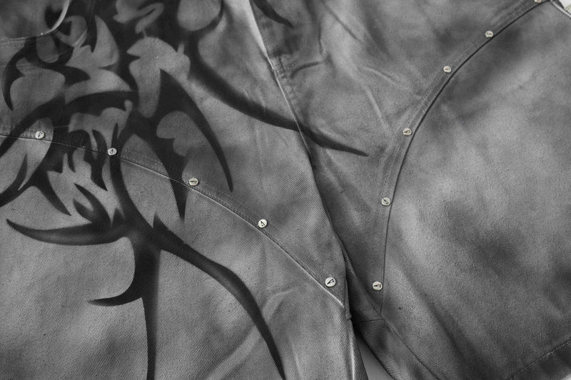 Close-up of gray jorts showing curved seam stitching and small silver studs