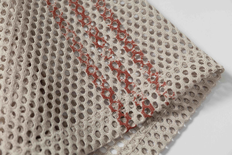Beige mesh football jersey fabric with red distressed stripes and oversized retro streetwear texture