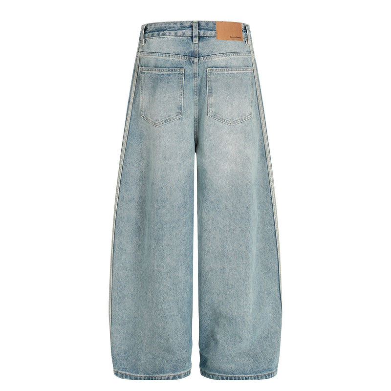 Light wash barrel jeans back view with patch pockets and tan logo label at waistband