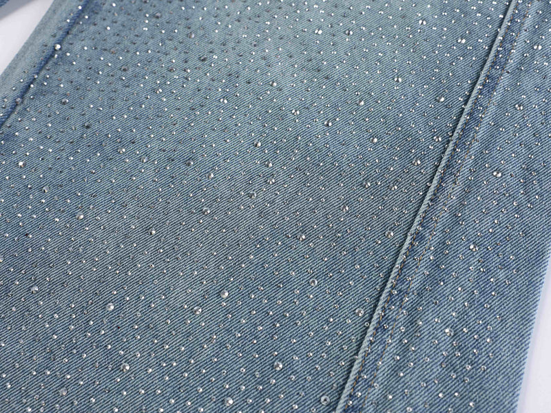 Light blue denim leg close-up with fine rhinestone speckles