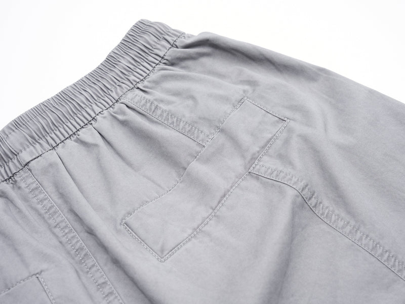 Close-up of gray shorts back pocket and waistband stitching