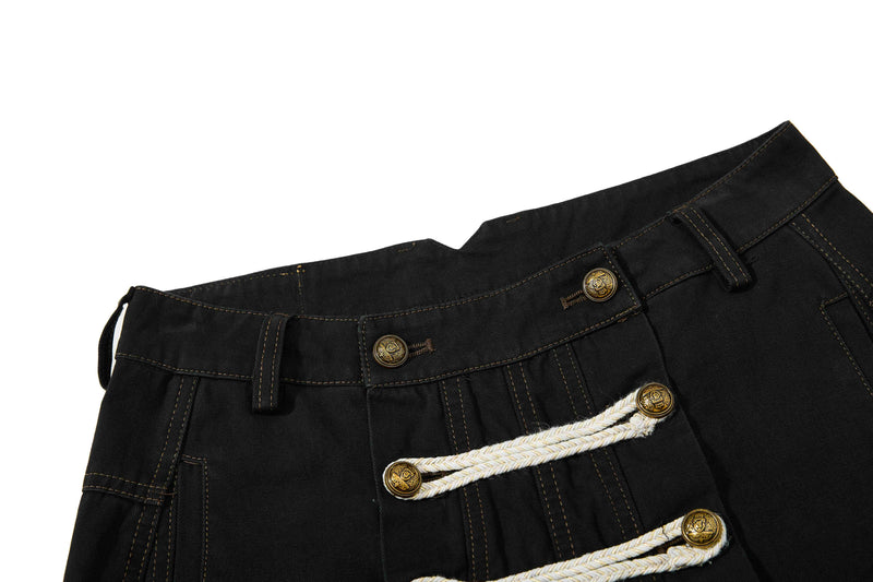 Close-up of black waistband and front closures with belt loops and leather patch