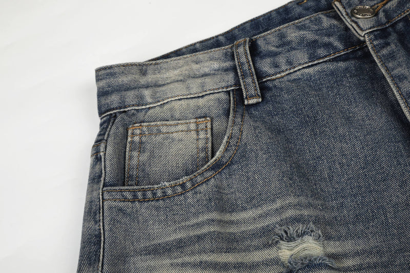 Close-up of front pocket and waistband on vintage-washed distressed jeans