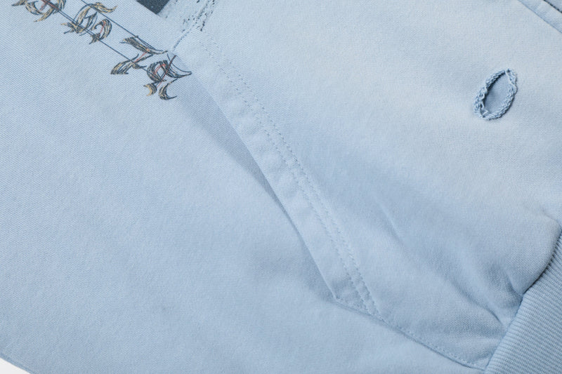 Close-up of light blue hoodie sleeve with distressed hole detail
