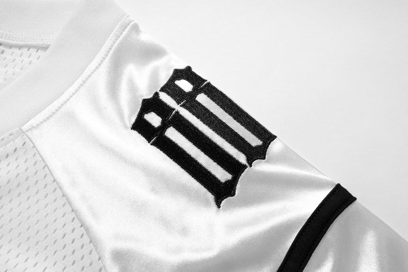 Close-up of white satin sleeve with black embroidered 88 detail