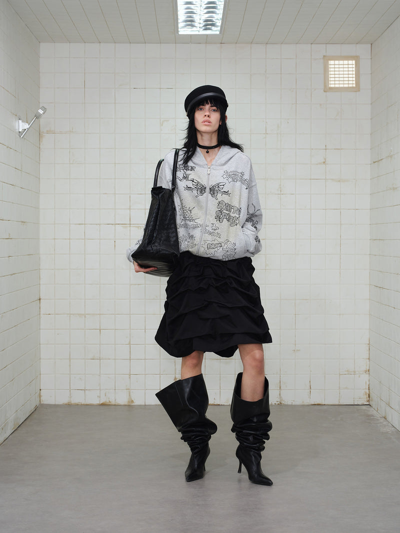 Grey zip hoodie with doodle print styled on model, full-body front view with black bag
