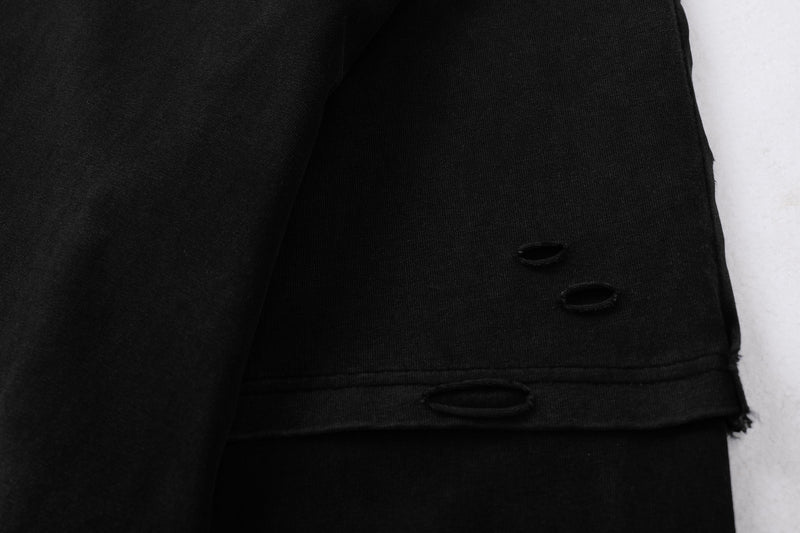 Close-up of black sleeve hem with torn holes and layered cuff detail