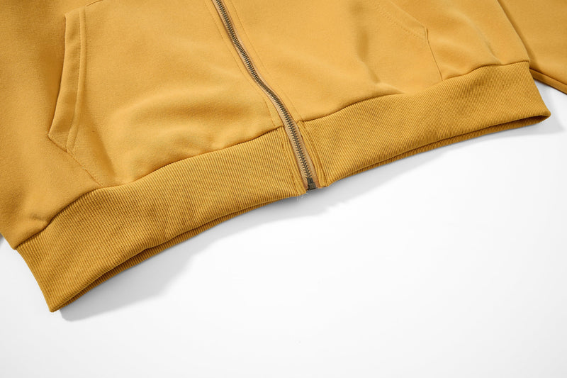 Close-up of mustard yellow hoodie lower hem and ribbed waistband
