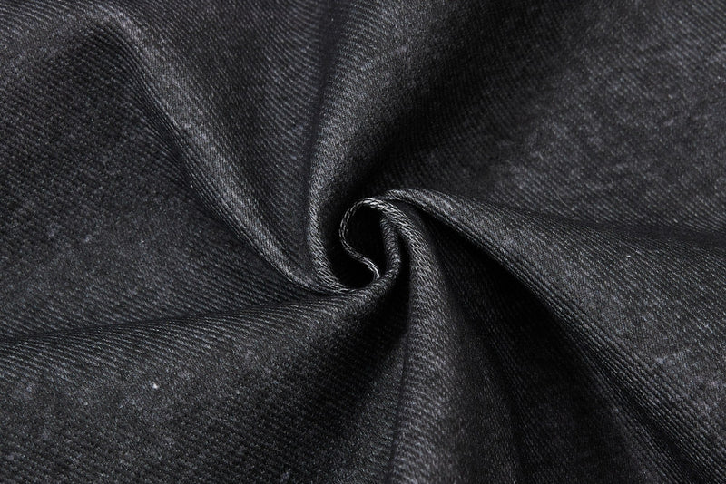 Close-up of black denim fabric swirl showing smooth drape and texture