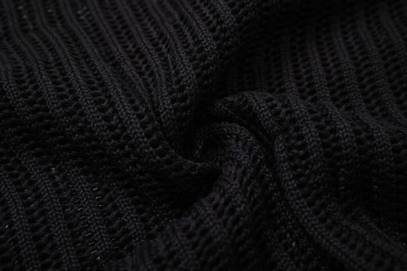 Close-up of black open-knit fabric with a textured star pattern on a short-sleeve button-up shirt