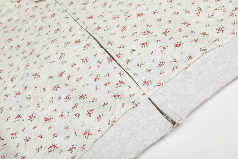 Close-up of floral hoodie front and side seam with zipper and ribbed hem