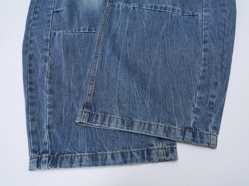 Close-up of lower leg panel seam and hem on blue denim jeans