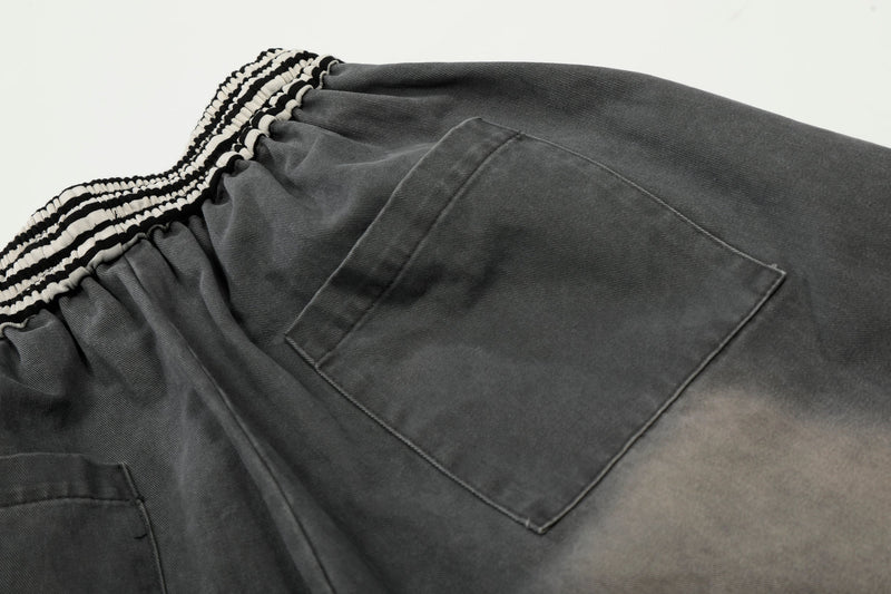 Close-up of back cargo pocket on charcoal washed pants with striped waistband