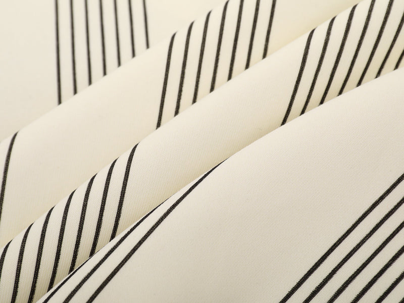 Close-up of cream pinstriped fabric with thin black vertical stripes