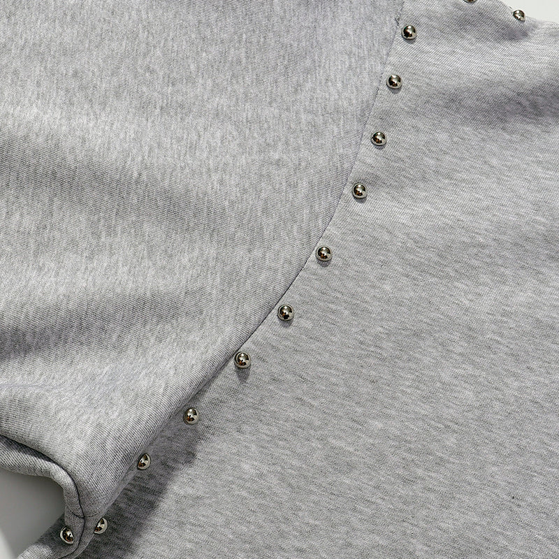 Gray zip hoodie close-up of curved studded seam on sleeve and chest