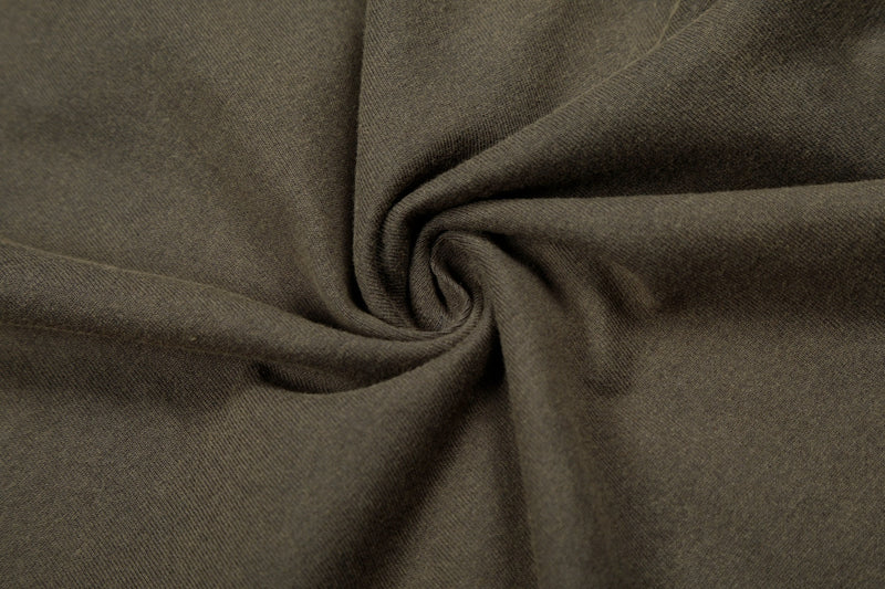 Close-up of olive vintage washed cotton fabric with soft texture and spiral folds for a streetwear graphic tee