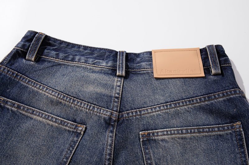 Close-up of the back waistband with tan leather patch and faded mid-blue denim