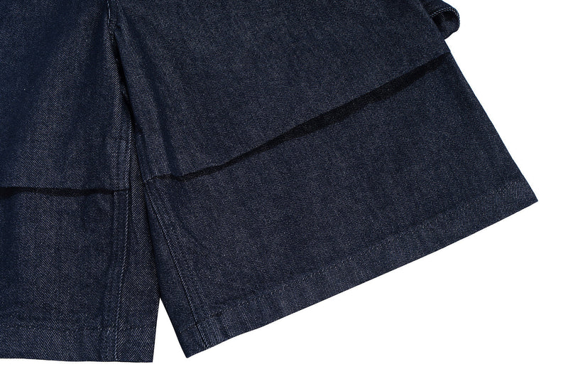 Close-up of wide leg opening and layered hem on dark indigo denim shorts