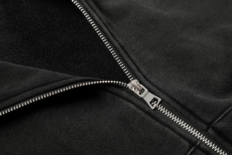 Close-up of silver zipper on black hoodie fabric