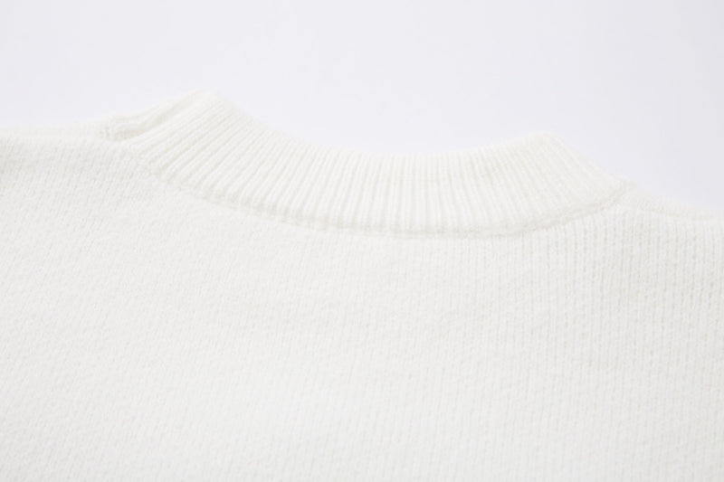 Close-up of white sweater sleeve cuff with ribbed knit texture