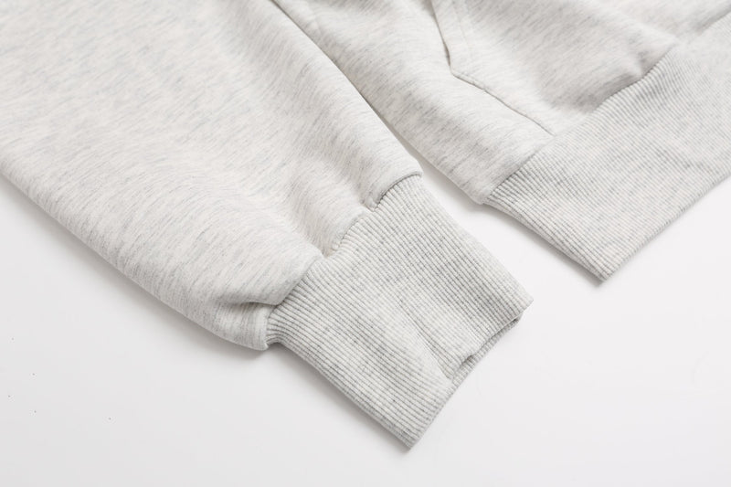 Close-up of light gray hoodie sleeve cuffs and ribbed wrist hems