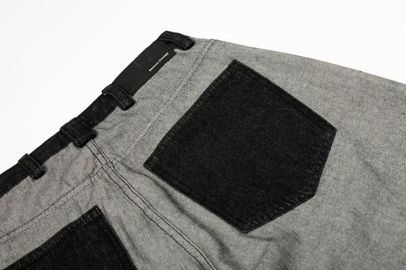Close-up of black back patch pocket on gray jeans with top waistband label