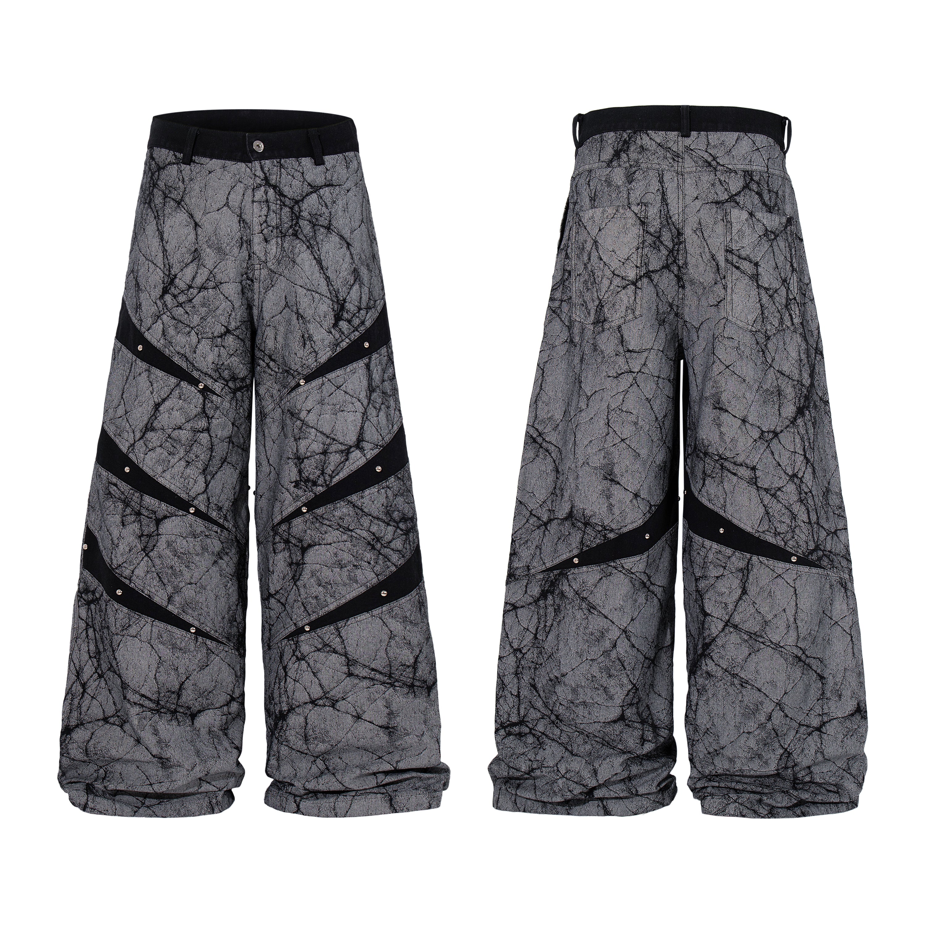 Grey wide leg denim pants with black cracked graphic print, diagonal riveted panel straps, shown front and back view