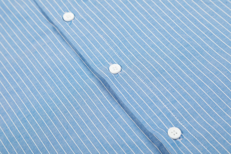 Close-up of blue striped shirt front placket with white buttons and stitched seam