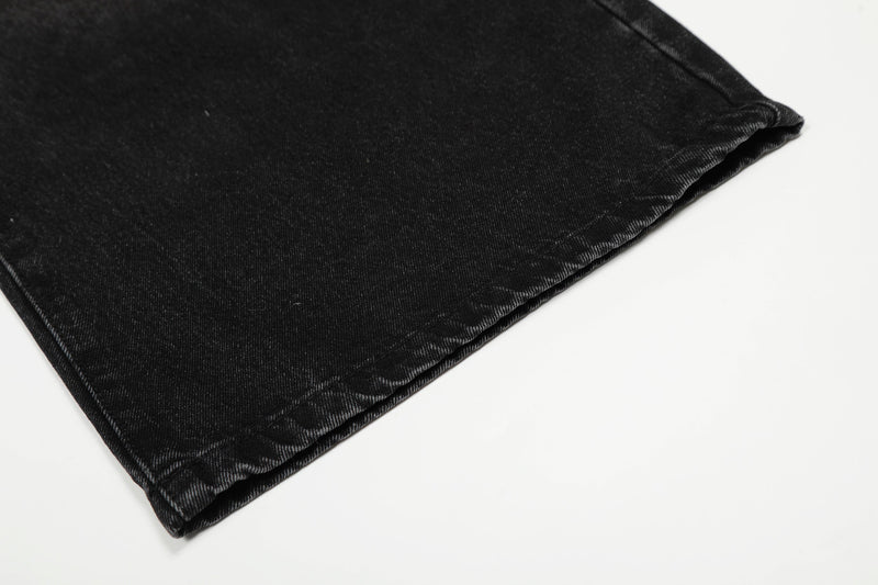Folded black jeans hem with visible denim stitching